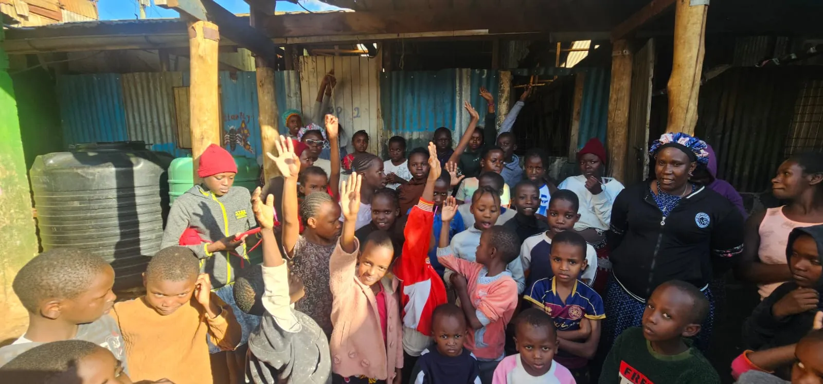 A group of children raising their hands together