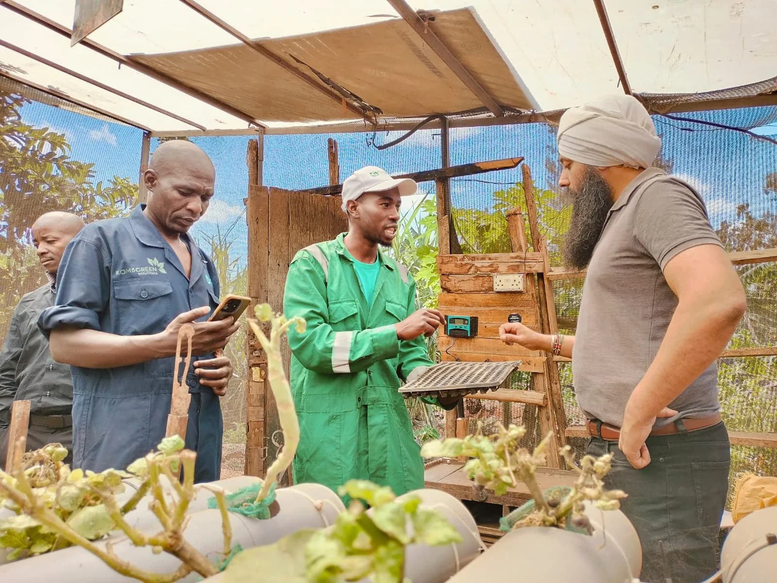 A young farmer showing seedling trays at the demonstration farm